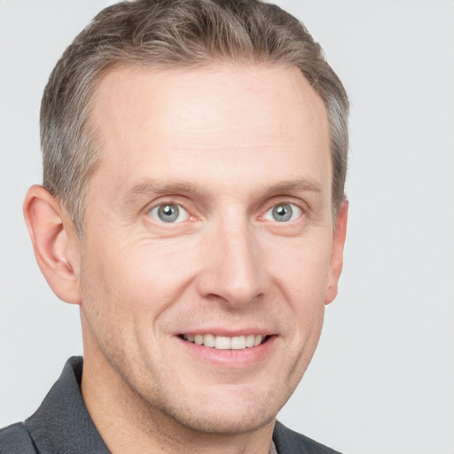 Joyful white adult male with short  brown hair and grey eyes