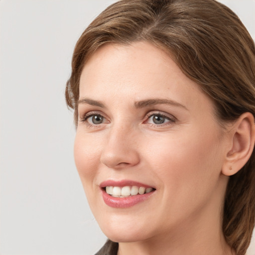 Joyful white young-adult female with medium  brown hair and grey eyes