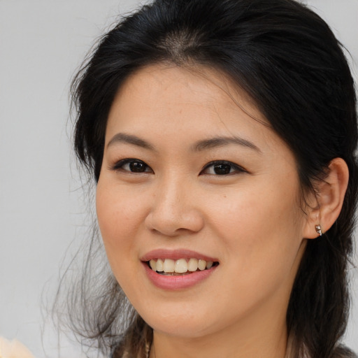 Joyful asian young-adult female with medium  brown hair and brown eyes