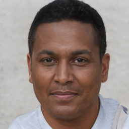 Joyful black adult male with short  black hair and brown eyes