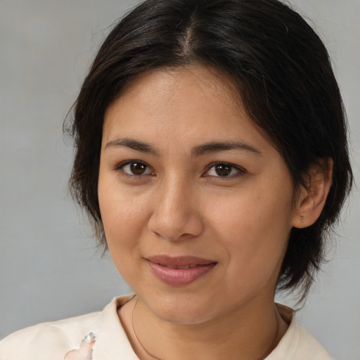 Joyful latino young-adult female with medium  brown hair and brown eyes