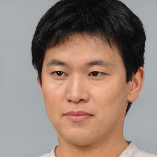 Joyful asian young-adult male with short  brown hair and brown eyes