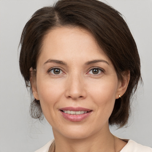 Joyful white adult female with medium  brown hair and brown eyes