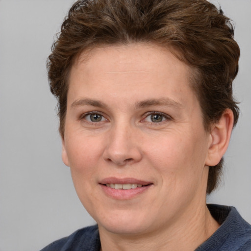 Joyful white adult female with short  brown hair and grey eyes