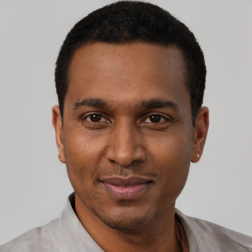 Joyful black adult male with short  black hair and brown eyes