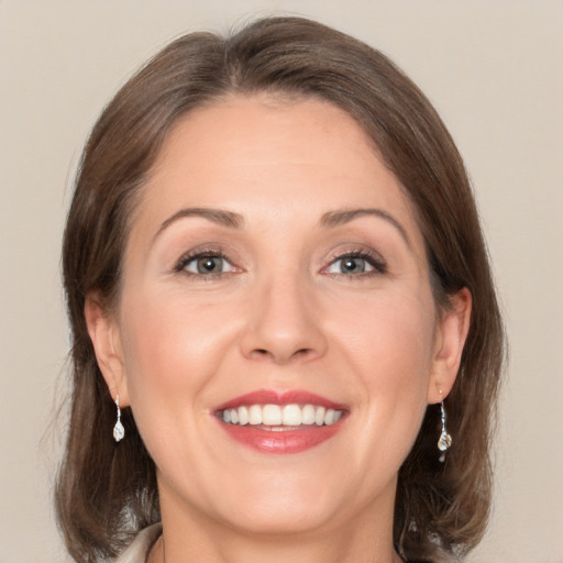 Joyful white adult female with medium  brown hair and grey eyes