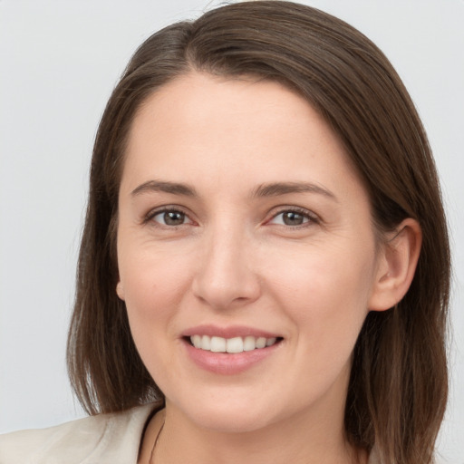 Joyful white young-adult female with medium  brown hair and grey eyes