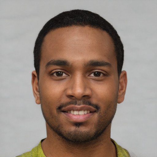 Joyful black young-adult male with short  black hair and brown eyes