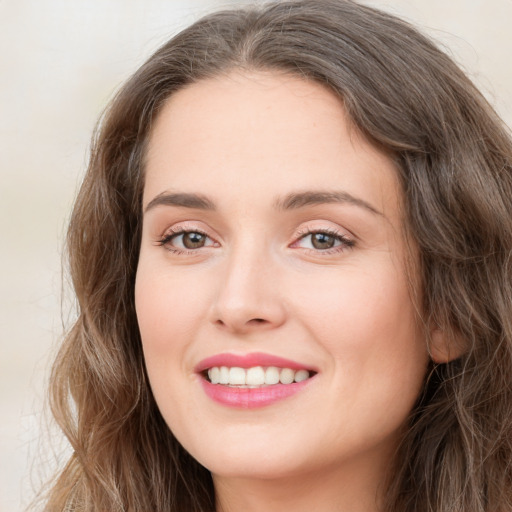 Joyful white young-adult female with long  brown hair and green eyes