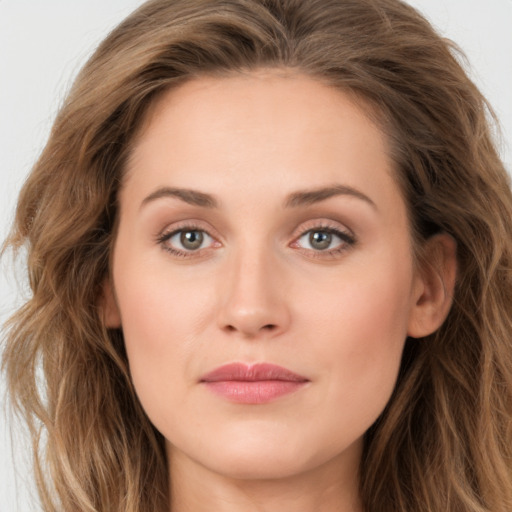 Joyful white young-adult female with long  brown hair and green eyes