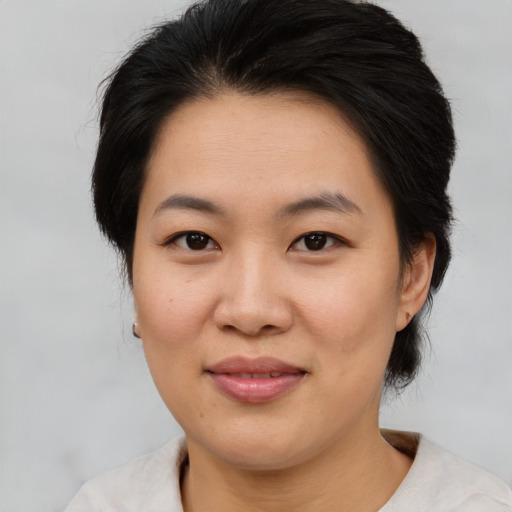 Joyful asian adult female with medium  brown hair and brown eyes