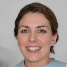 Joyful white young-adult female with medium  brown hair and blue eyes