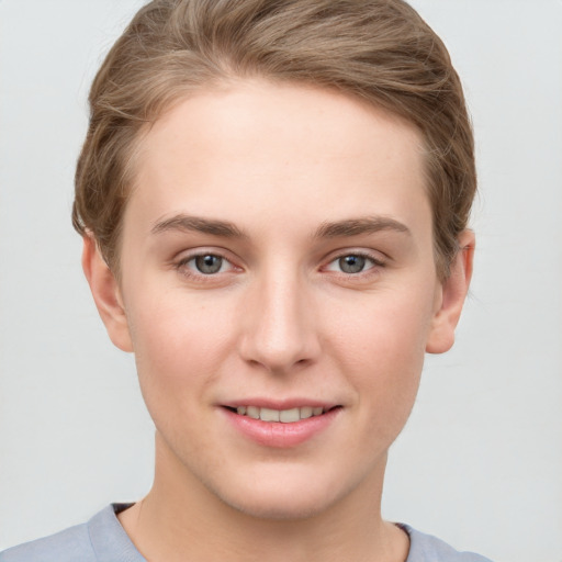 Joyful white young-adult female with short  brown hair and blue eyes