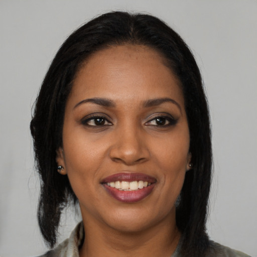 Joyful black young-adult female with long  brown hair and brown eyes
