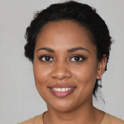 Joyful black young-adult female with medium  black hair and brown eyes