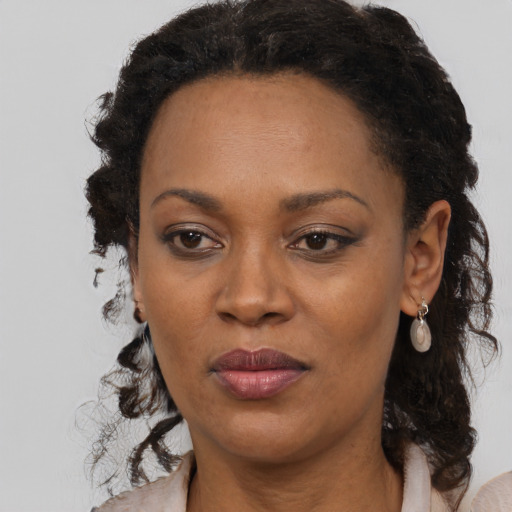 Joyful black adult female with long  brown hair and brown eyes