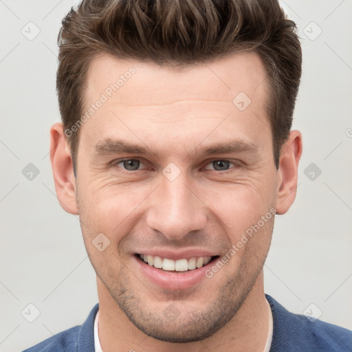 Joyful white young-adult male with short  brown hair and grey eyes