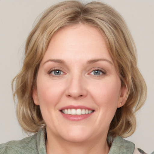 Joyful white adult female with medium  brown hair and blue eyes