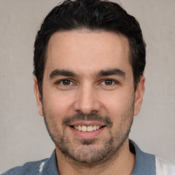 Joyful white young-adult male with short  black hair and brown eyes