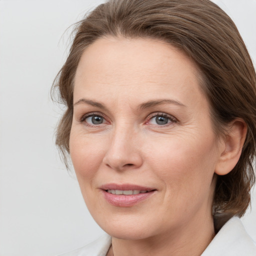 Joyful white adult female with medium  brown hair and grey eyes