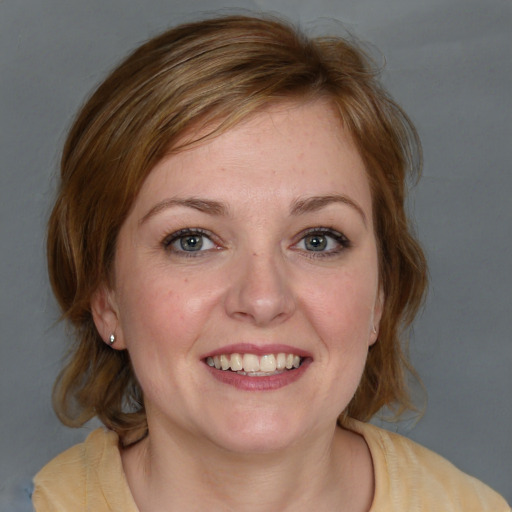 Joyful white young-adult female with medium  brown hair and blue eyes