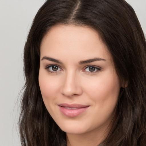 Joyful white young-adult female with long  brown hair and brown eyes