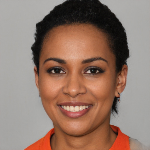 Joyful black young-adult female with short  black hair and brown eyes