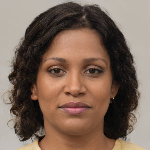 Joyful black young-adult female with medium  brown hair and brown eyes