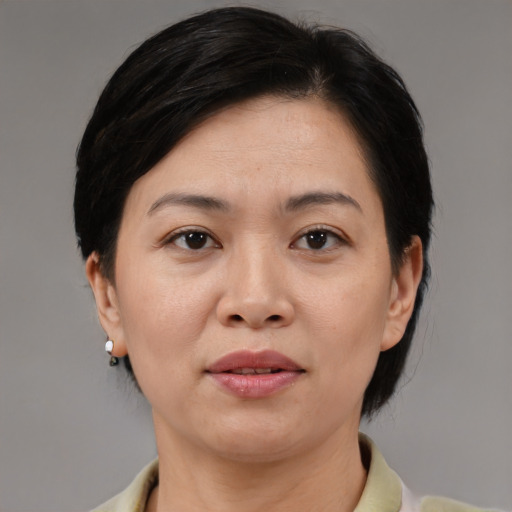 Joyful asian adult female with medium  brown hair and brown eyes