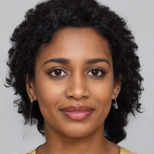Joyful black young-adult female with medium  black hair and brown eyes