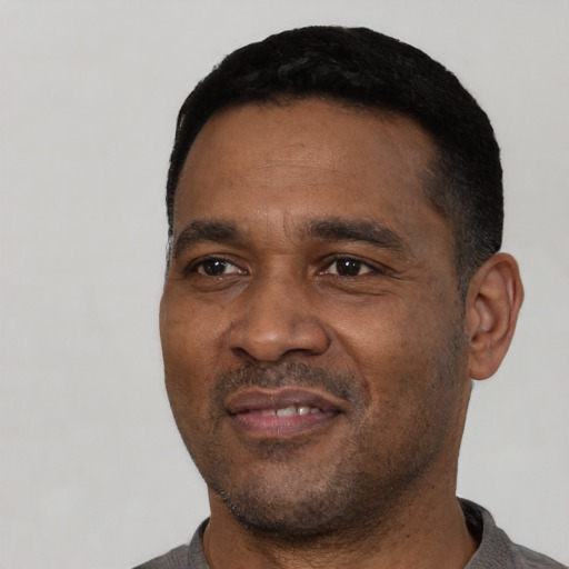 Joyful latino adult male with short  black hair and brown eyes