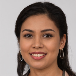 Joyful latino young-adult female with long  brown hair and brown eyes