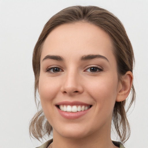 Joyful white young-adult female with medium  brown hair and grey eyes