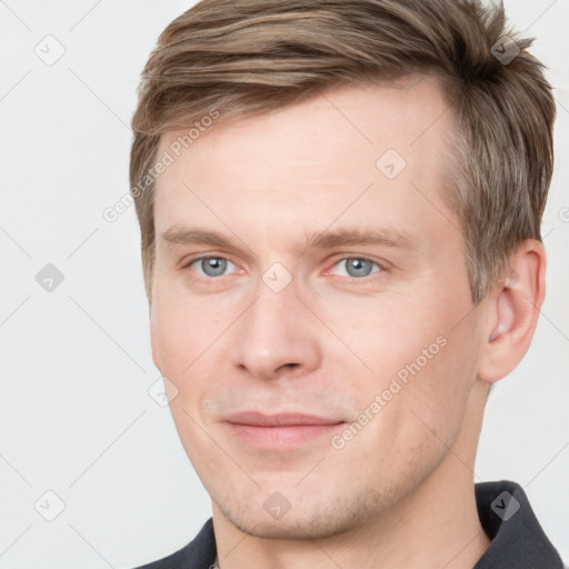 Joyful white young-adult male with short  brown hair and grey eyes