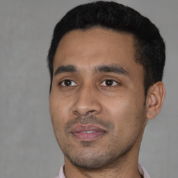 Joyful latino young-adult male with short  black hair and brown eyes