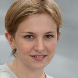 Joyful white young-adult female with medium  brown hair and grey eyes