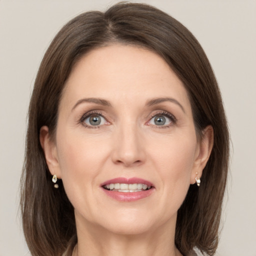 Joyful white adult female with medium  brown hair and grey eyes