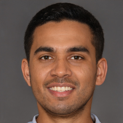 Joyful latino young-adult male with short  brown hair and brown eyes