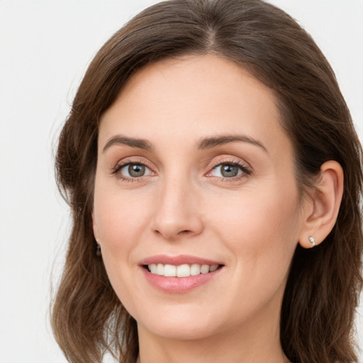 Joyful white young-adult female with long  brown hair and green eyes