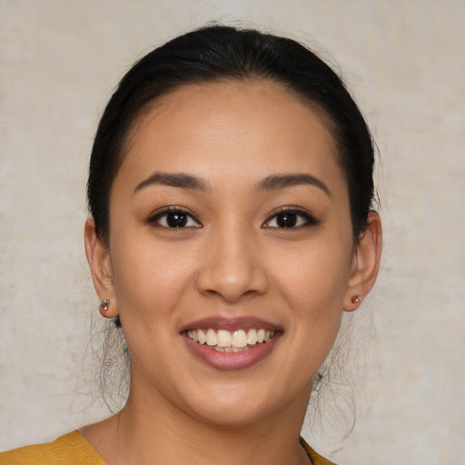 Joyful latino young-adult female with medium  brown hair and brown eyes