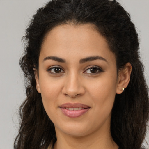 Joyful latino young-adult female with long  brown hair and brown eyes