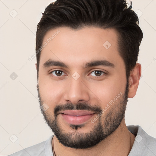 Joyful white young-adult male with short  black hair and brown eyes