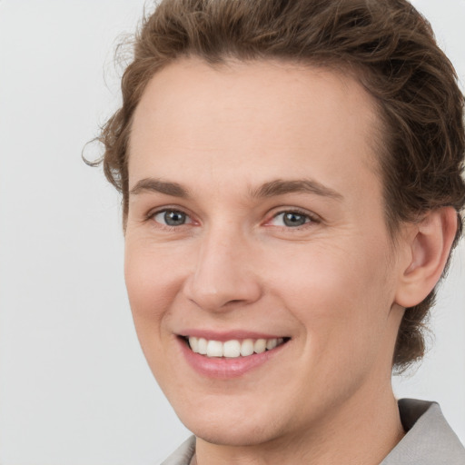 Joyful white young-adult female with short  brown hair and grey eyes