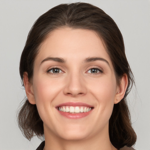 Joyful white young-adult female with medium  brown hair and grey eyes