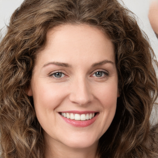 Joyful white young-adult female with long  brown hair and green eyes