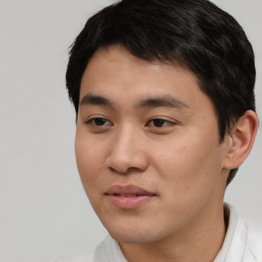 Joyful asian young-adult male with short  brown hair and brown eyes