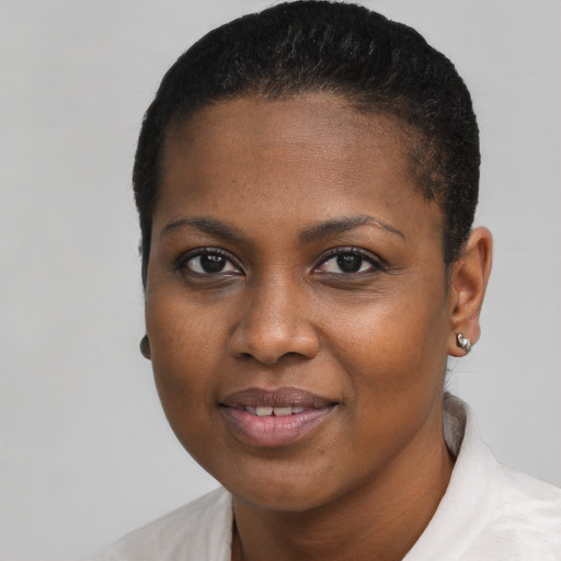 Joyful black young-adult female with short  black hair and brown eyes