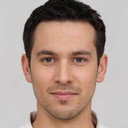 Joyful white young-adult male with short  brown hair and brown eyes