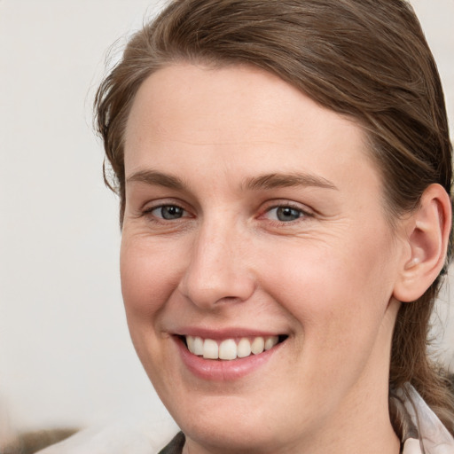 Joyful white young-adult female with long  brown hair and grey eyes