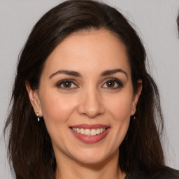 Joyful white adult female with long  brown hair and brown eyes